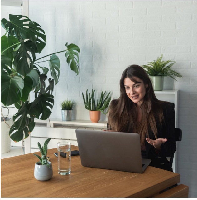 A counsellor working at a laptop beside houseplants