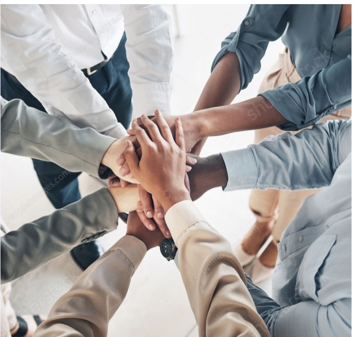 A team joining hands together in a circle